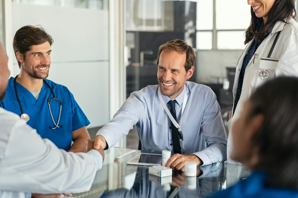 Salesman shaking hands with doctor